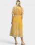 Woman wearing a yellow floral dress on a white background