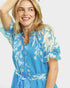 Woman wearing a blue floral dress on a white background