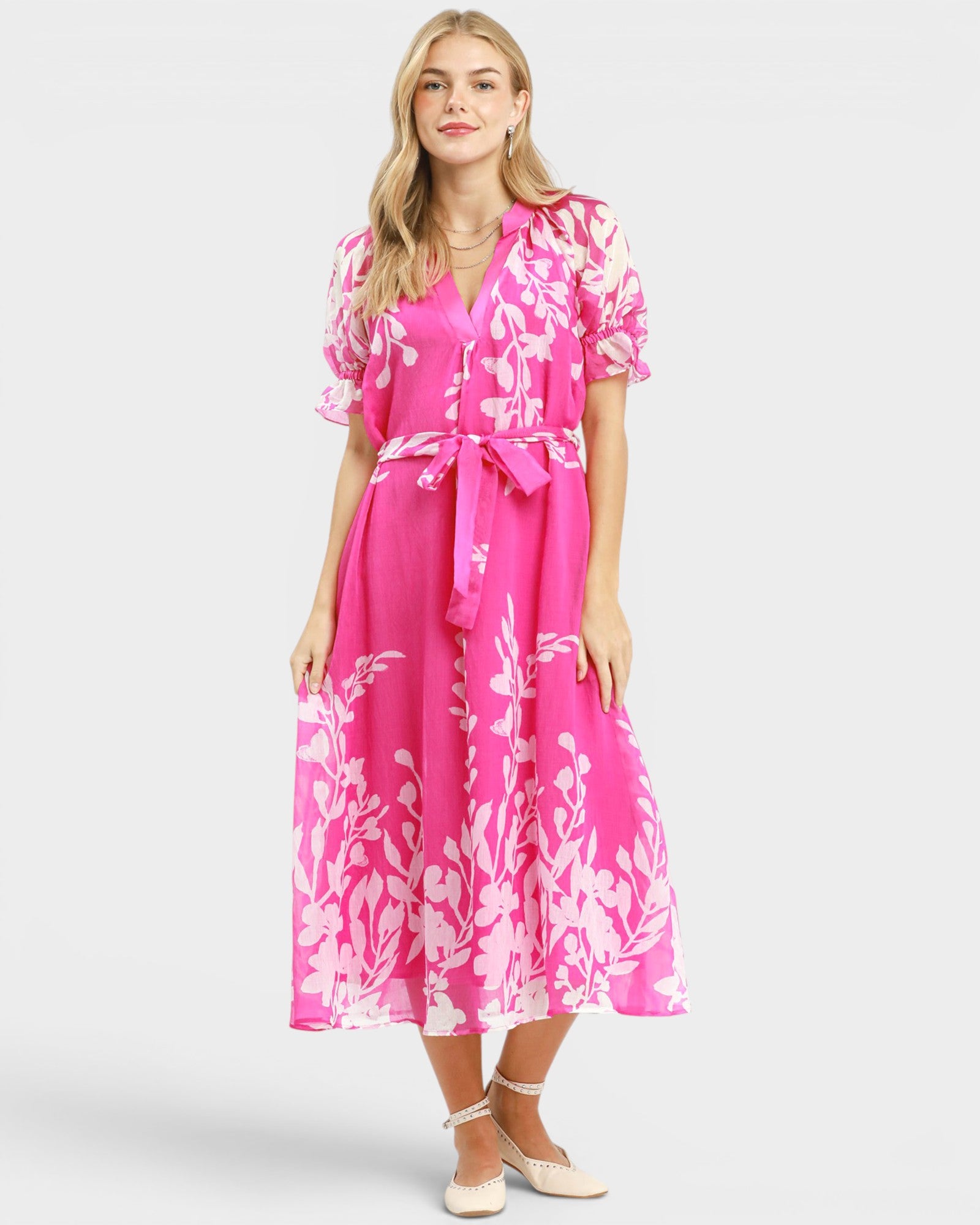 Woman wearing a pink floral dress on a white background