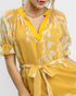 Yellow floral dress worn by a model on a plain background