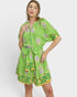 Woman wearing a green dress with floral patterns on a white background