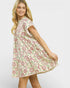Woman wearing a floral dress on a plain background