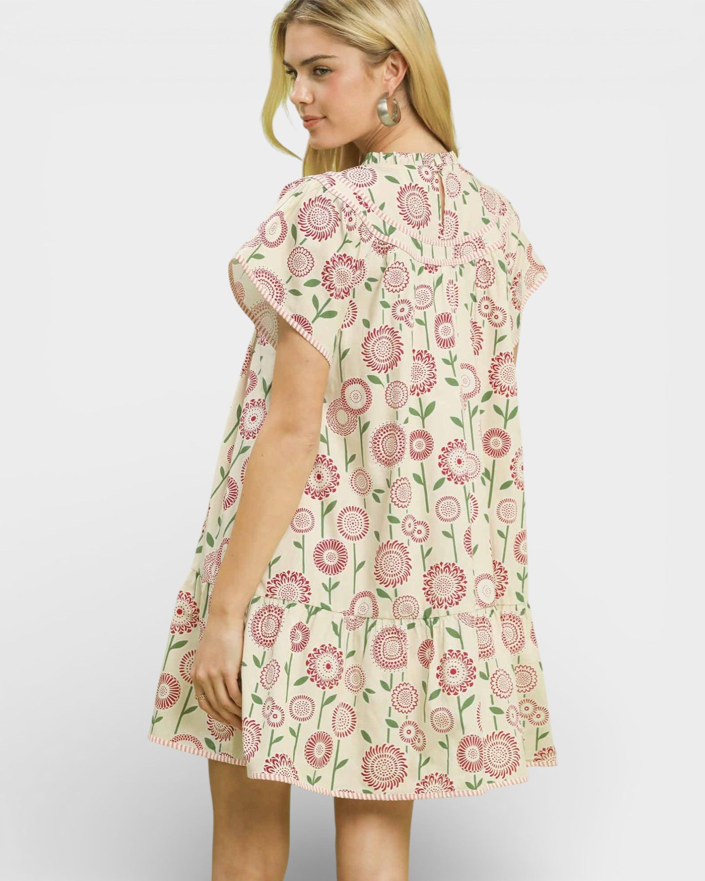 Woman wearing a floral dress on a plain background