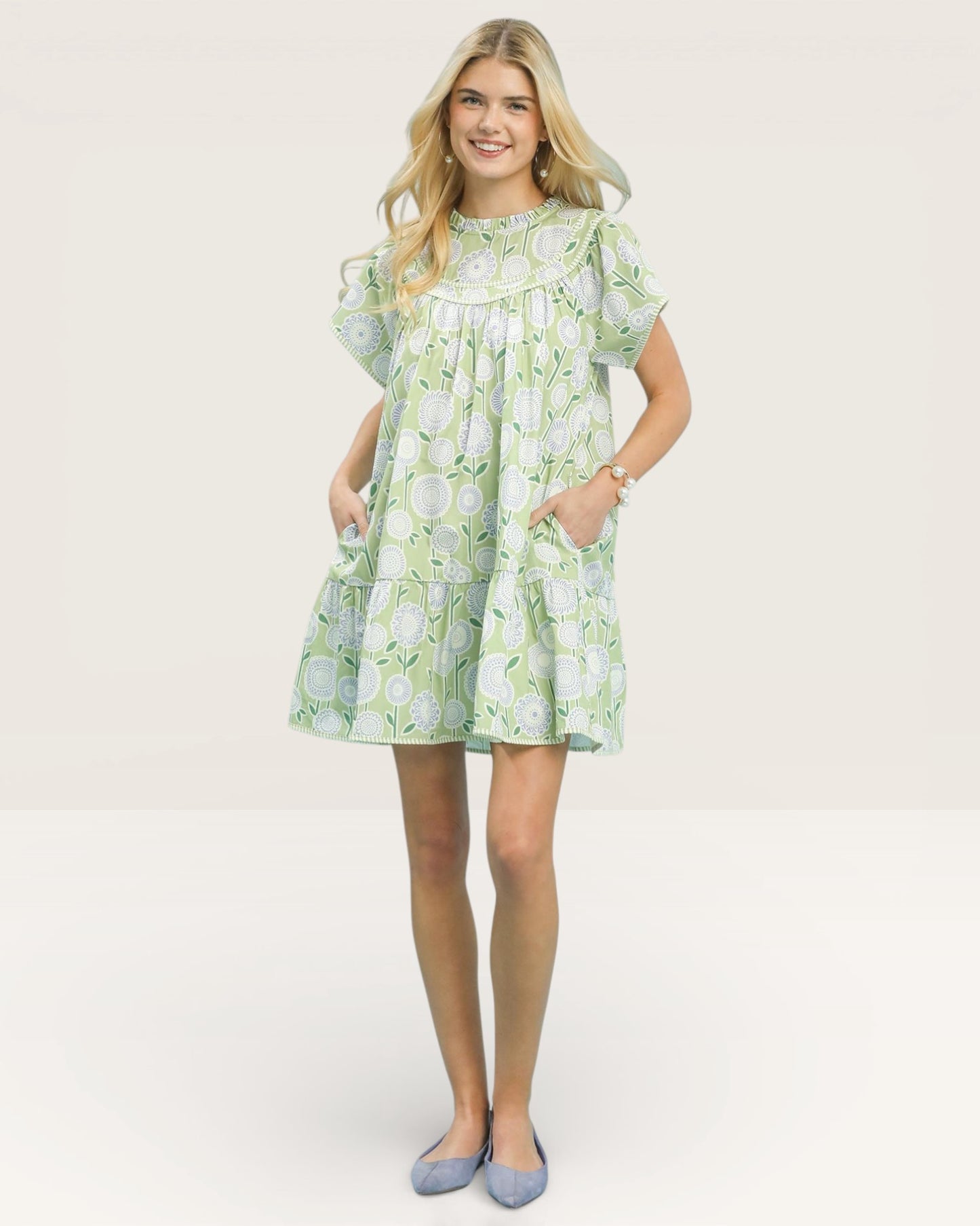 Woman wearing a green floral dress on a white background