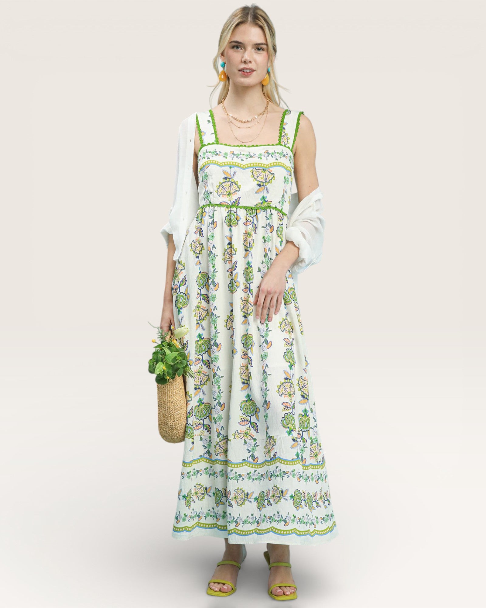 Woman wearing a floral dress holding a bag with a white background