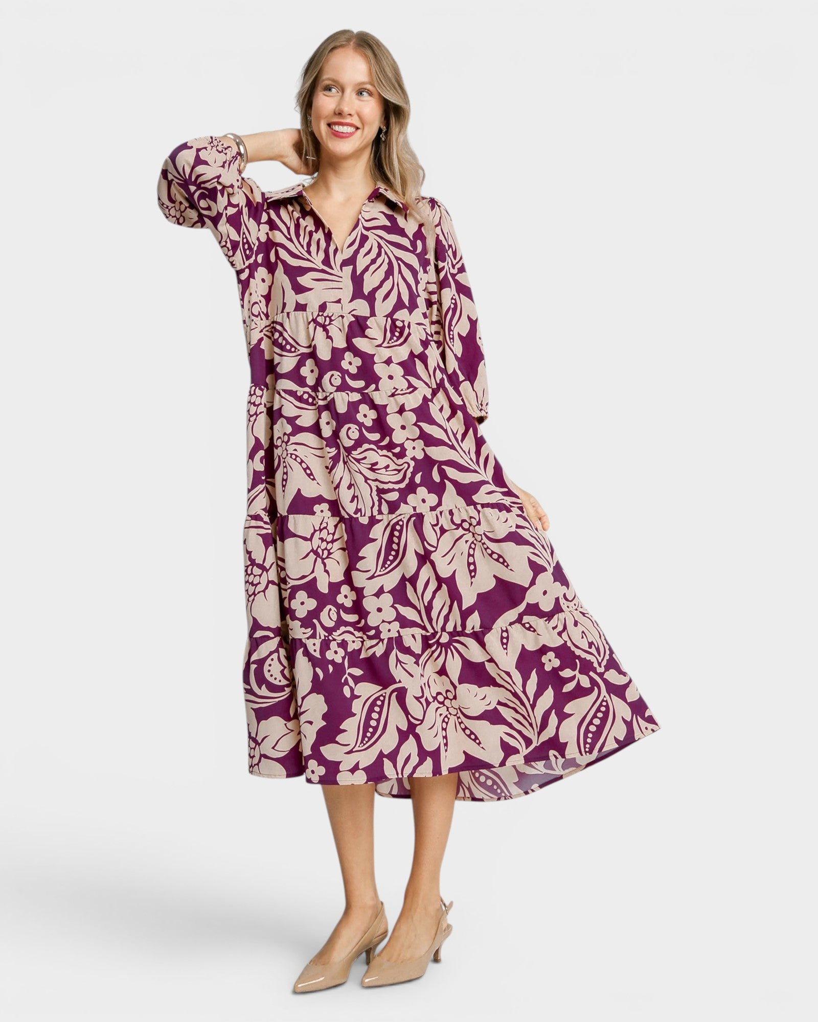 Woman wearing a purple floral dress on a white background