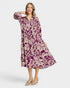 Woman wearing a purple floral dress on a white background