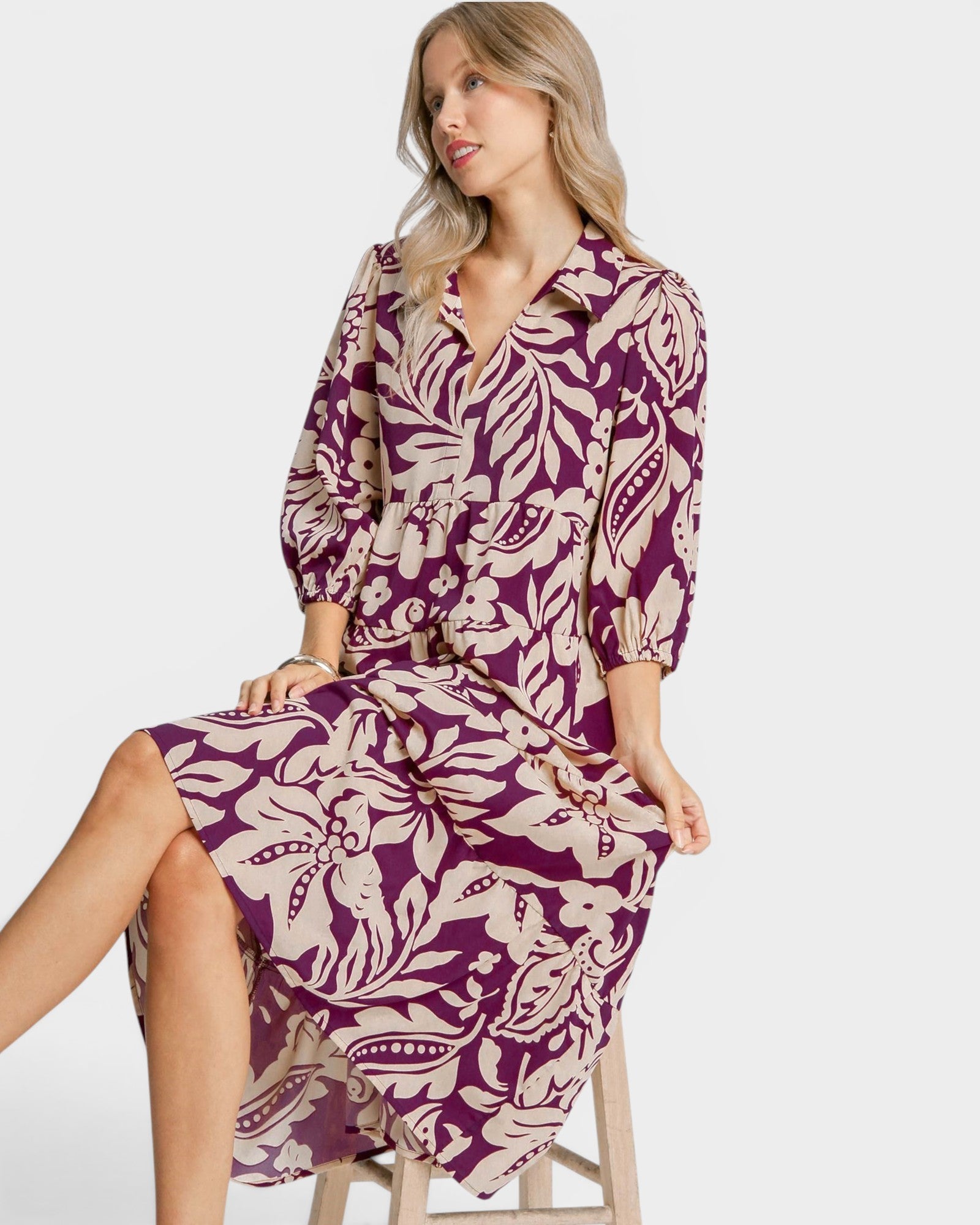 Woman wearing a purple and beige patterned dress on a white background