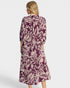 Woman wearing a purple floral dress on a white background