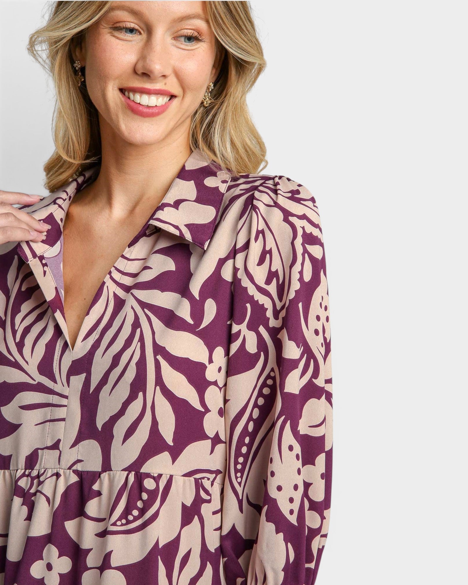 Woman wearing a purple and beige patterned dress on a white background