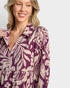 Woman wearing a purple and beige patterned dress on a white background