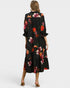Woman wearing a black floral dress on a white background