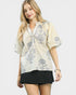 Woman wearing a floral blouse and black skirt on a white background