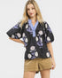 Woman wearing a black floral blouse with a white background