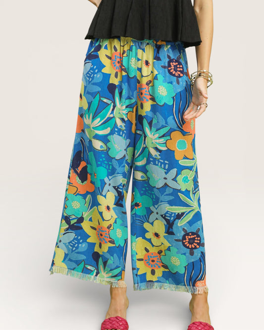 Colorful floral-patterned pants worn by a person on a white background