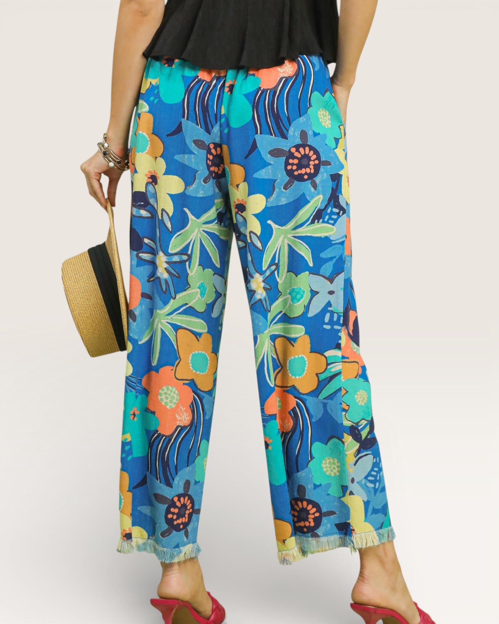 Colorful floral-patterned pants worn by a person on a plain background