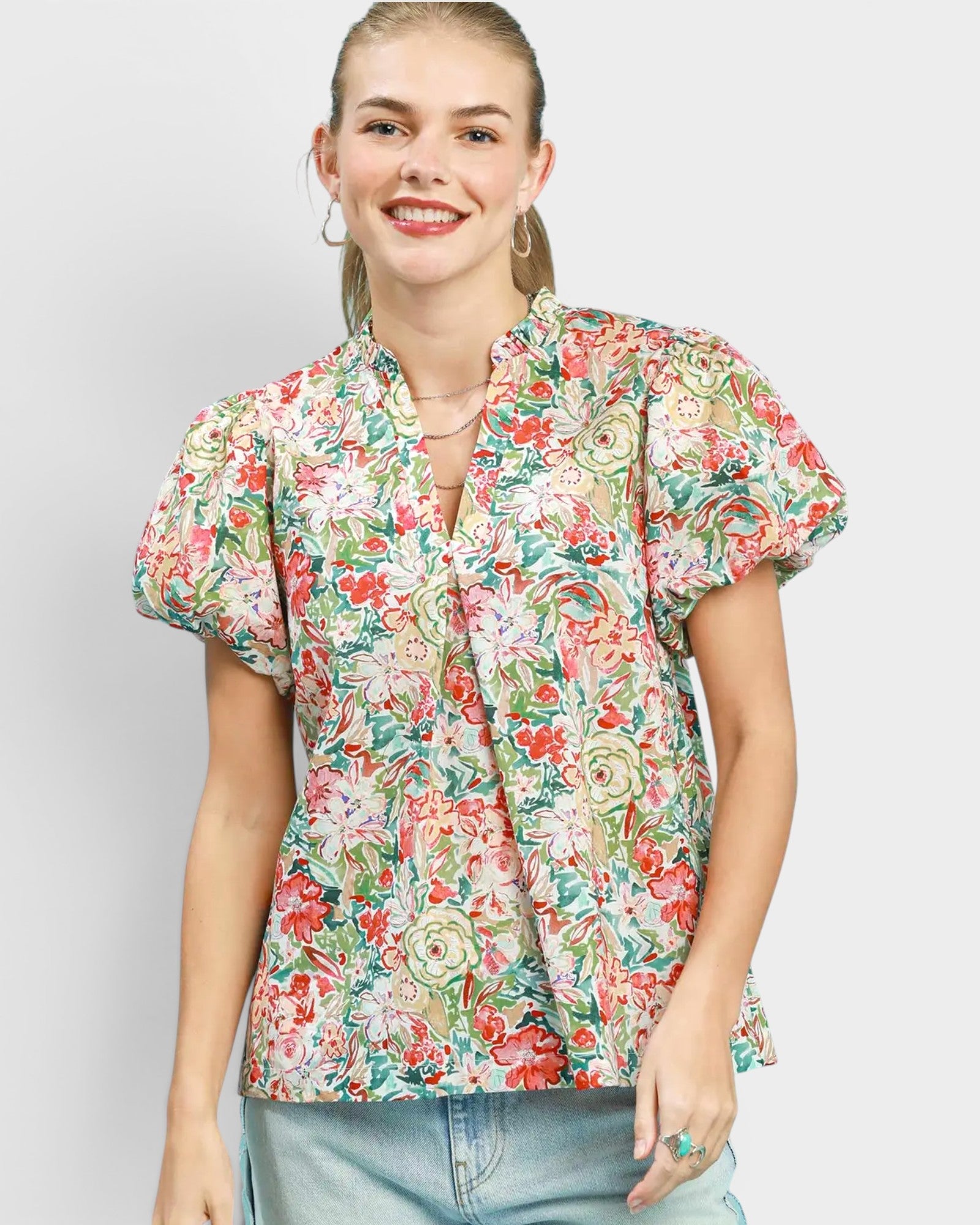 Woman wearing a floral blouse against a plain background