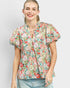 Woman wearing a floral blouse against a plain background
