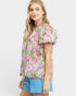 Woman wearing a floral blouse with puff sleeves on a white background