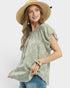Woman wearing a green floral blouse and straw hat on a white background