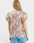 Woman wearing a floral blouse with puffed sleeves on a white background