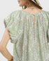 Green floral dress worn by a person on a white background