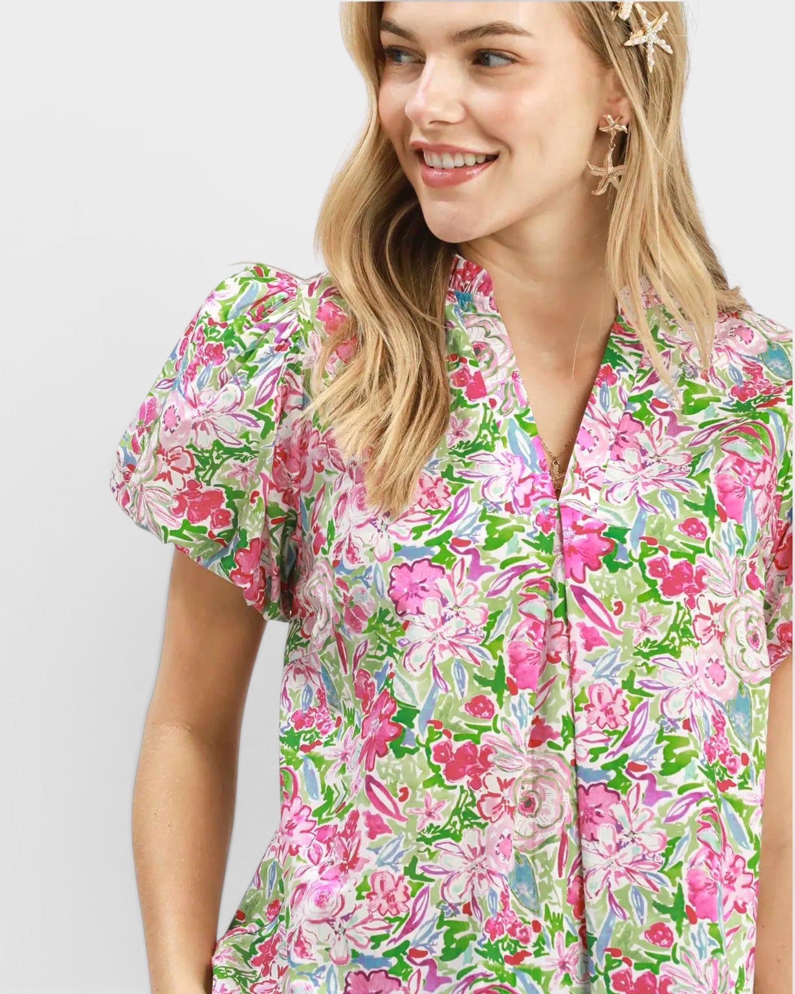Woman wearing a colorful floral dress against a white background