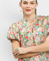 Woman wearing a floral blouse with a plain background
