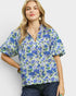 Woman wearing a blue floral blouse against a white background