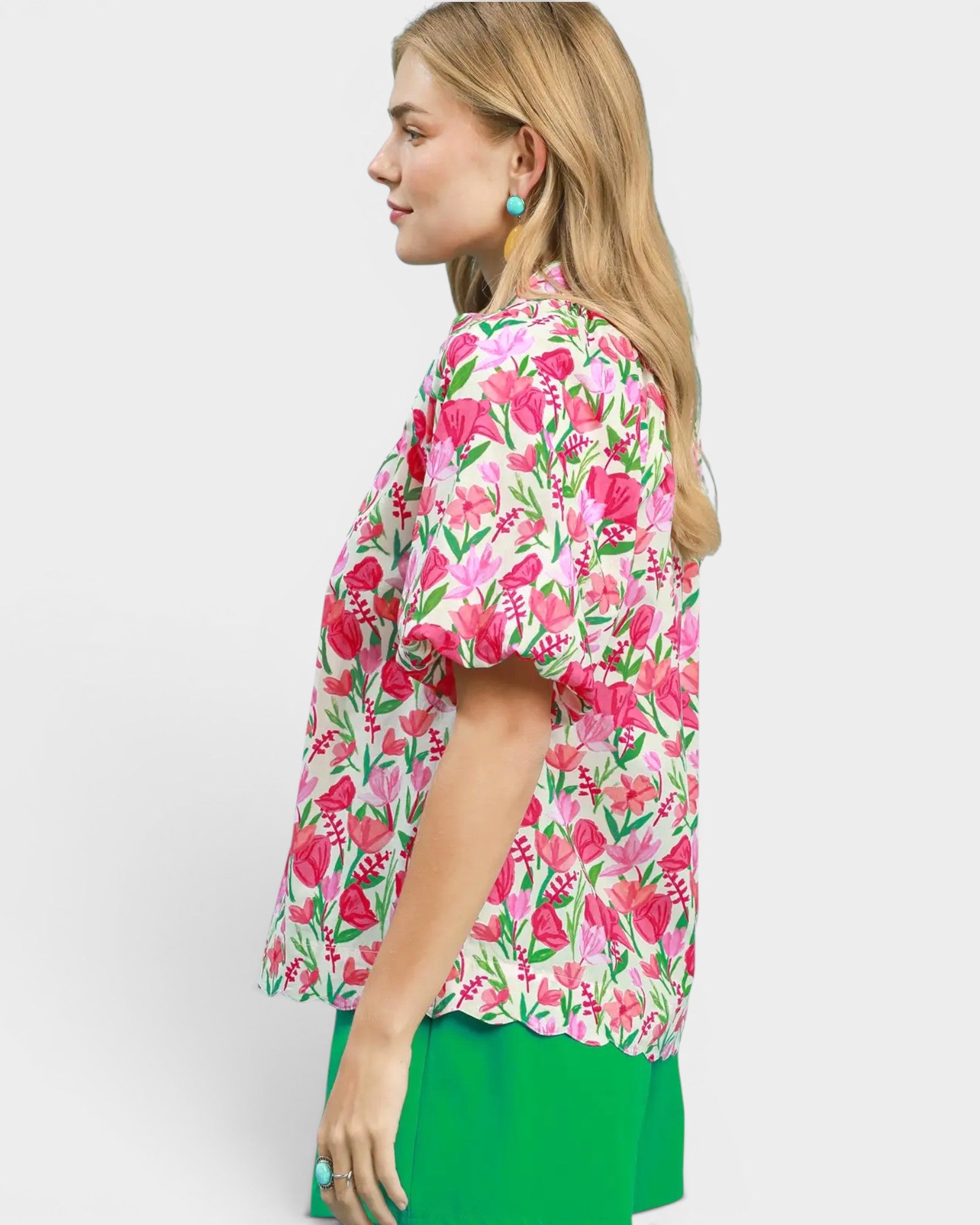 Woman wearing a floral blouse with pink flowers on a white background