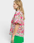 Woman wearing a floral blouse with pink flowers on a white background