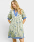 Woman wearing a floral dress with blue accents on a white background