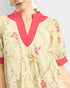 Woman wearing a floral dress with pink accents on a plain background