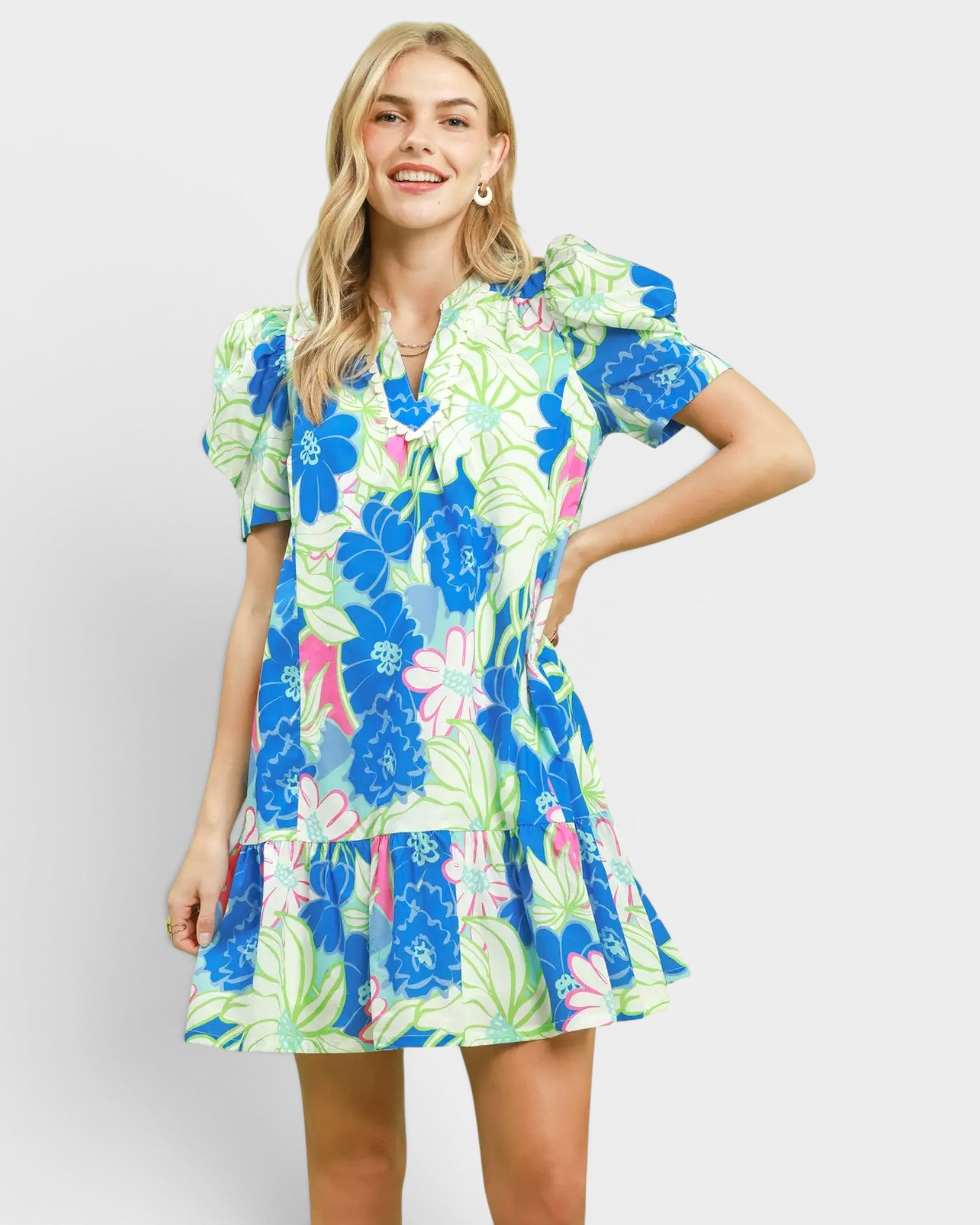 Woman wearing a colorful floral dress on a plain background