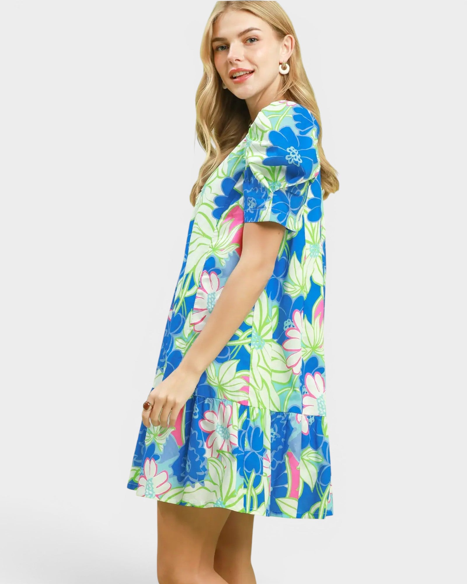 Woman wearing a colorful floral dress on a white background