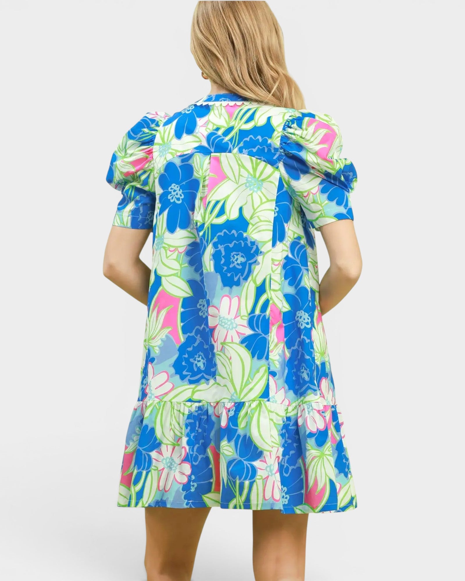 Woman wearing a colorful floral dress on a white background
