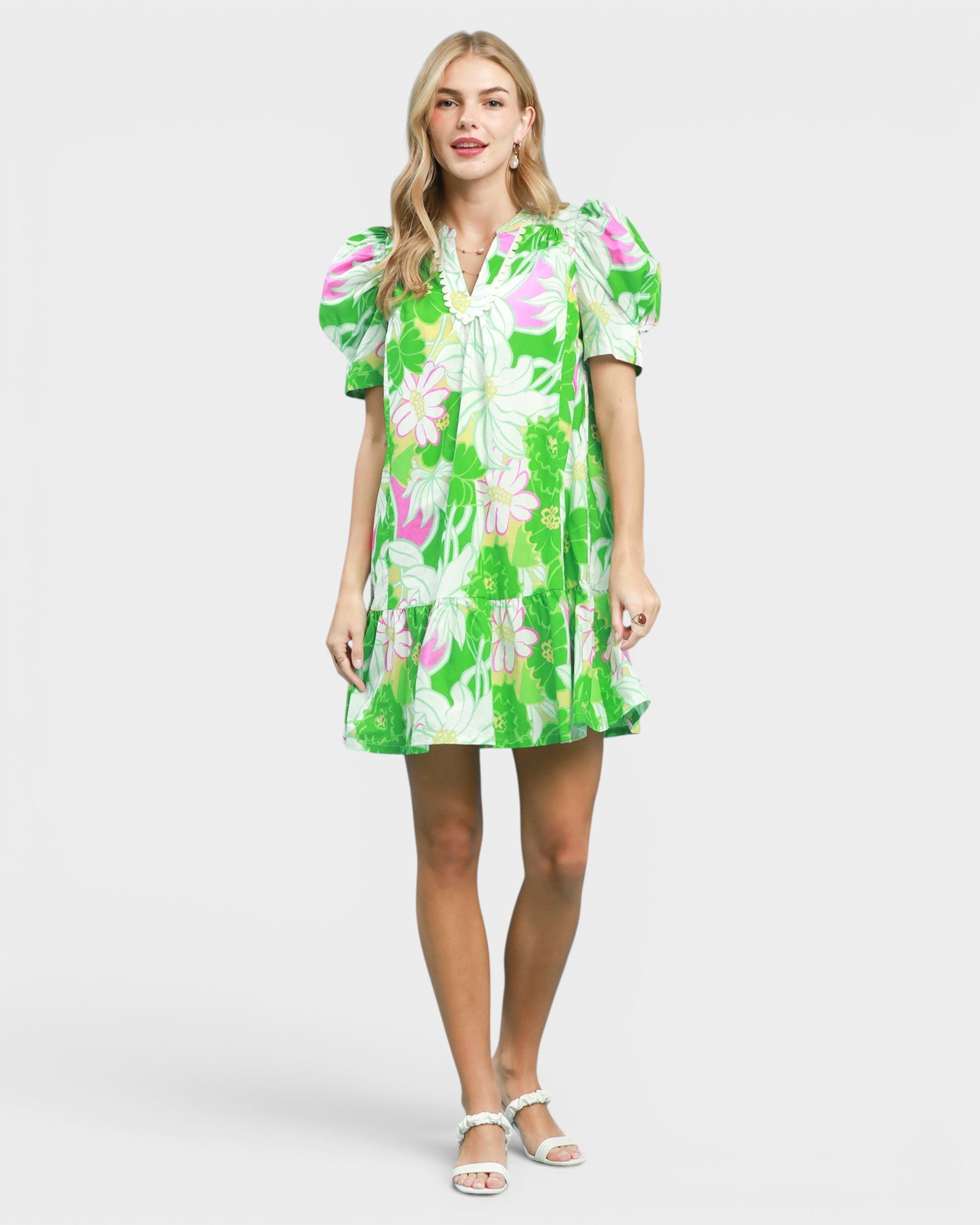 Woman wearing a green floral dress on a white background
