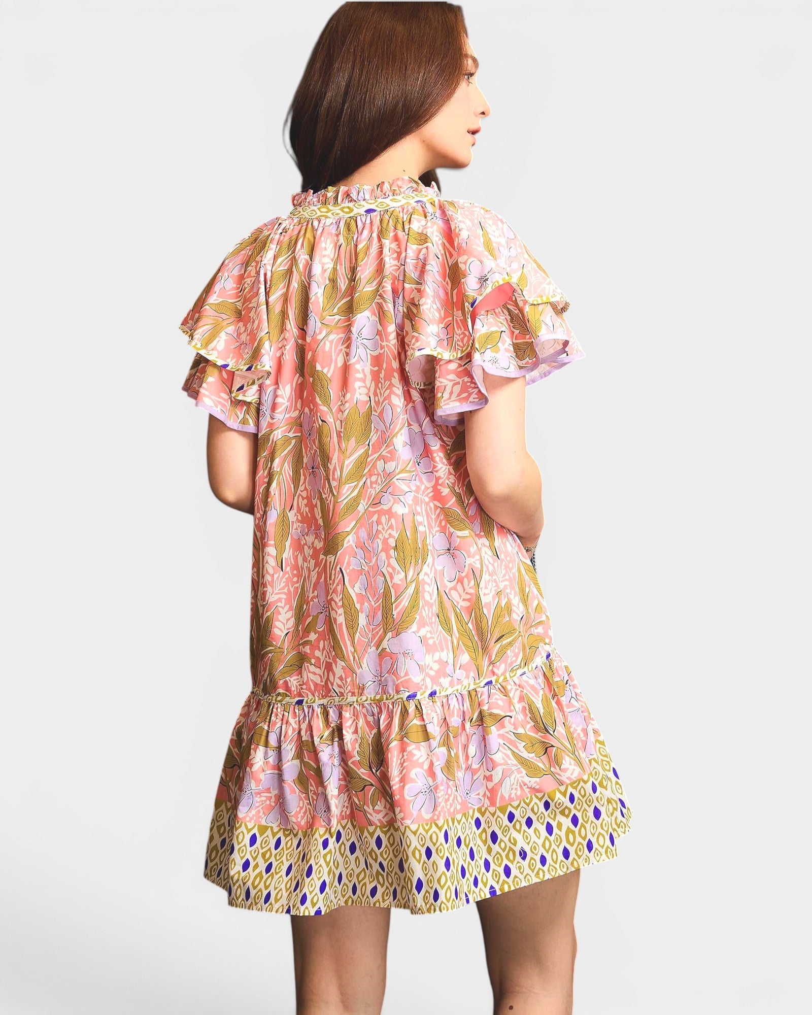 Woman wearing a colorful floral dress on a white background