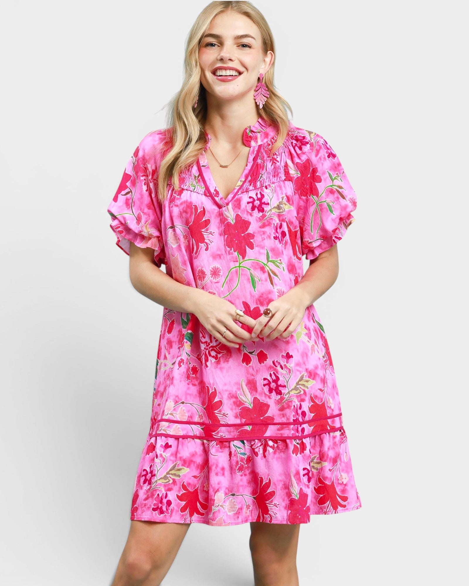 Woman wearing a pink floral dress on a white background