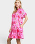 Woman wearing a pink floral dress on a white background