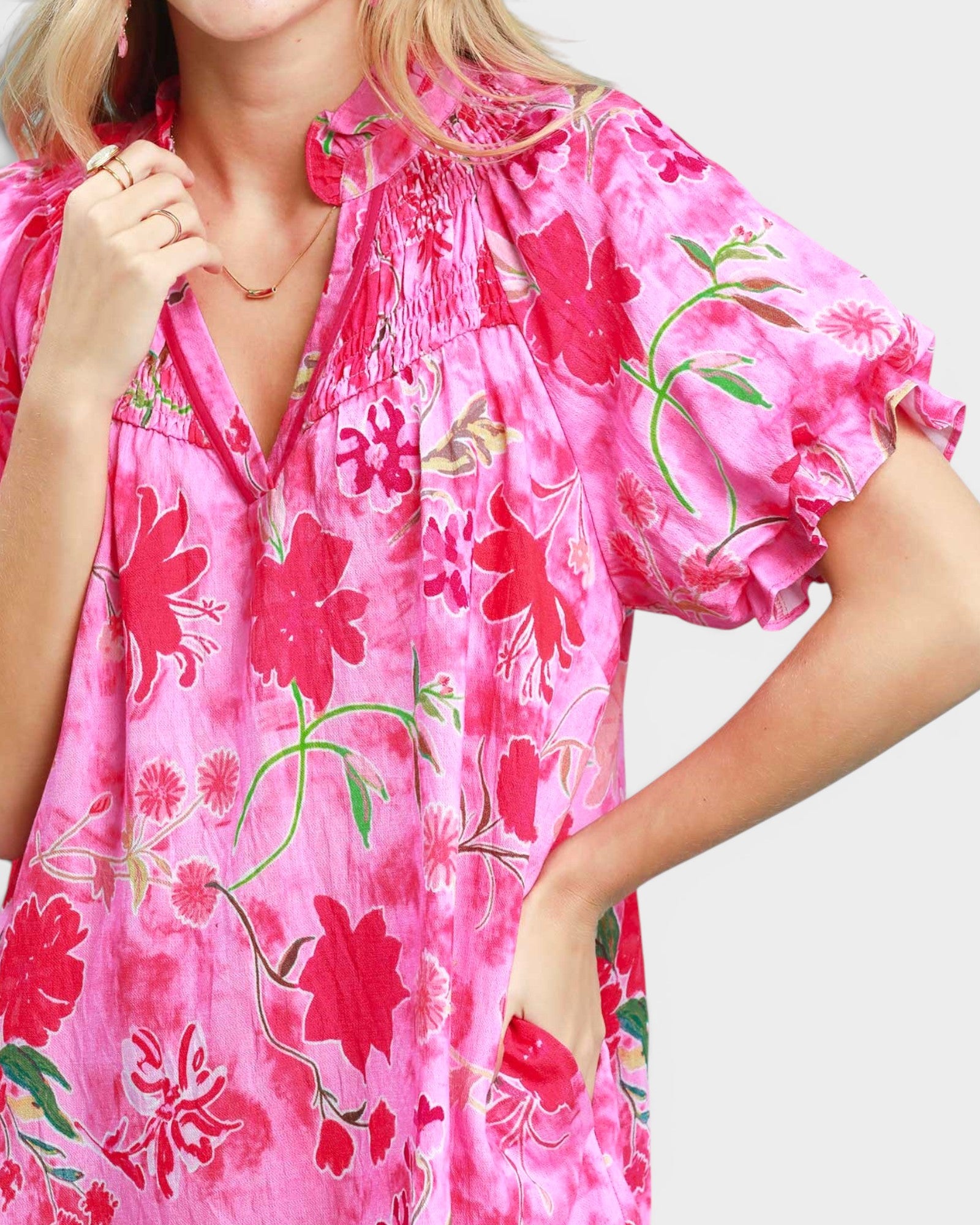 Woman wearing a pink floral dress on a white background