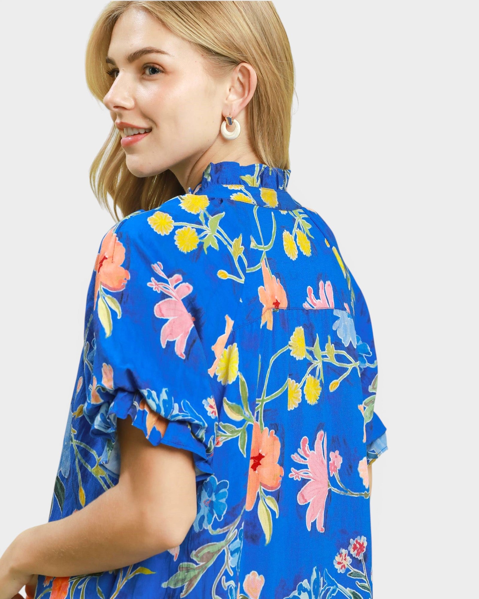 Woman wearing a blue floral blouse on a light gray background