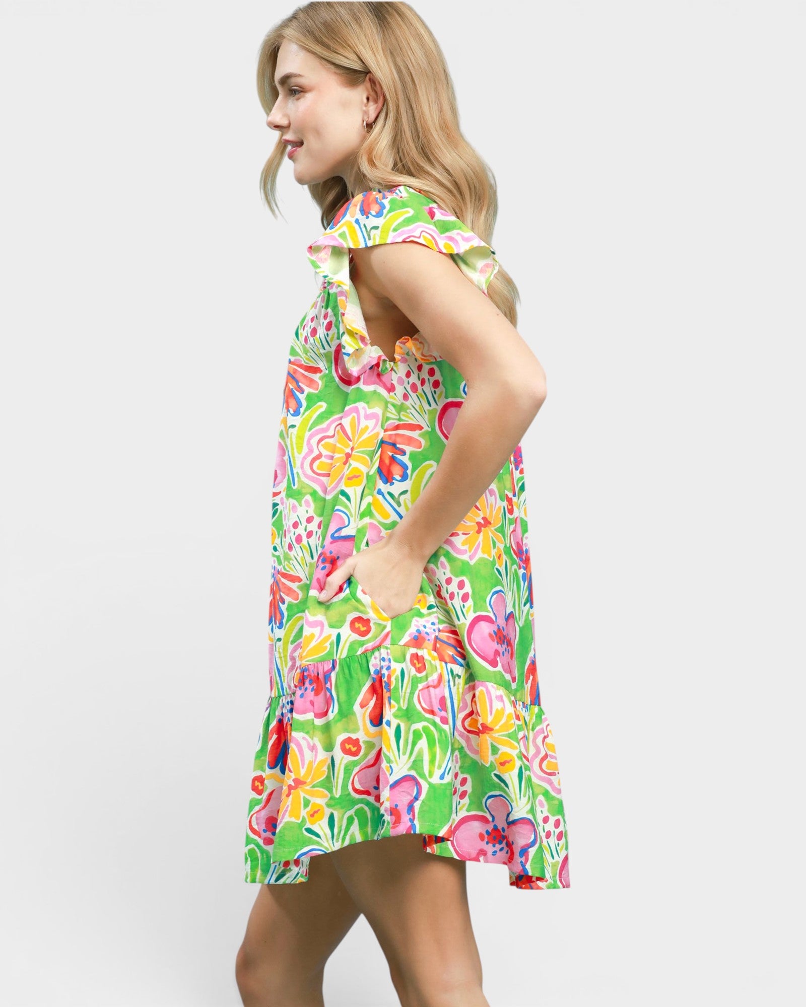 Woman wearing a colorful floral dress on a white background