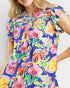 Woman wearing a colorful floral dress on a white background