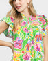 Woman wearing a colorful floral dress on a plain background