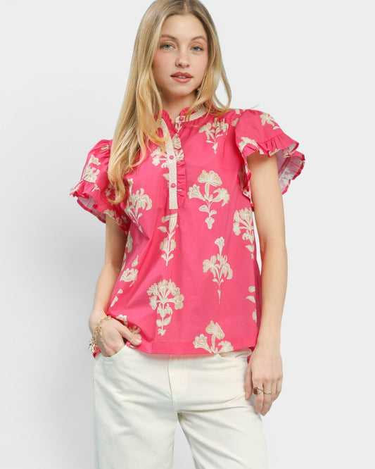 Woman wearing a pink floral blouse against a white background
