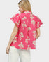 Woman wearing a pink floral blouse with ruffled sleeves on a white background