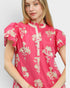 Woman wearing a pink floral blouse against a white background