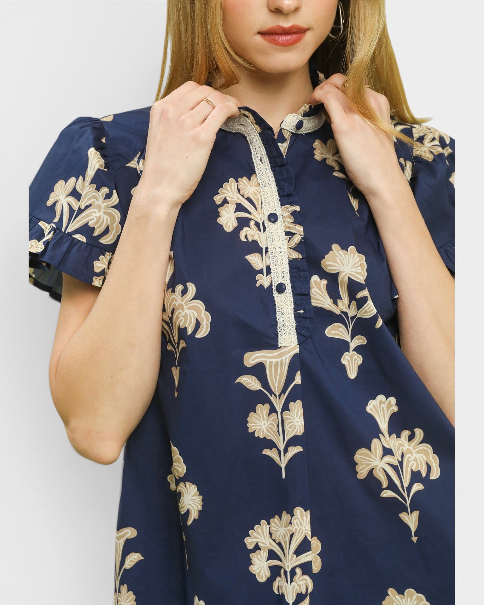 Navy blue dress with beige floral embroidery on a plain background