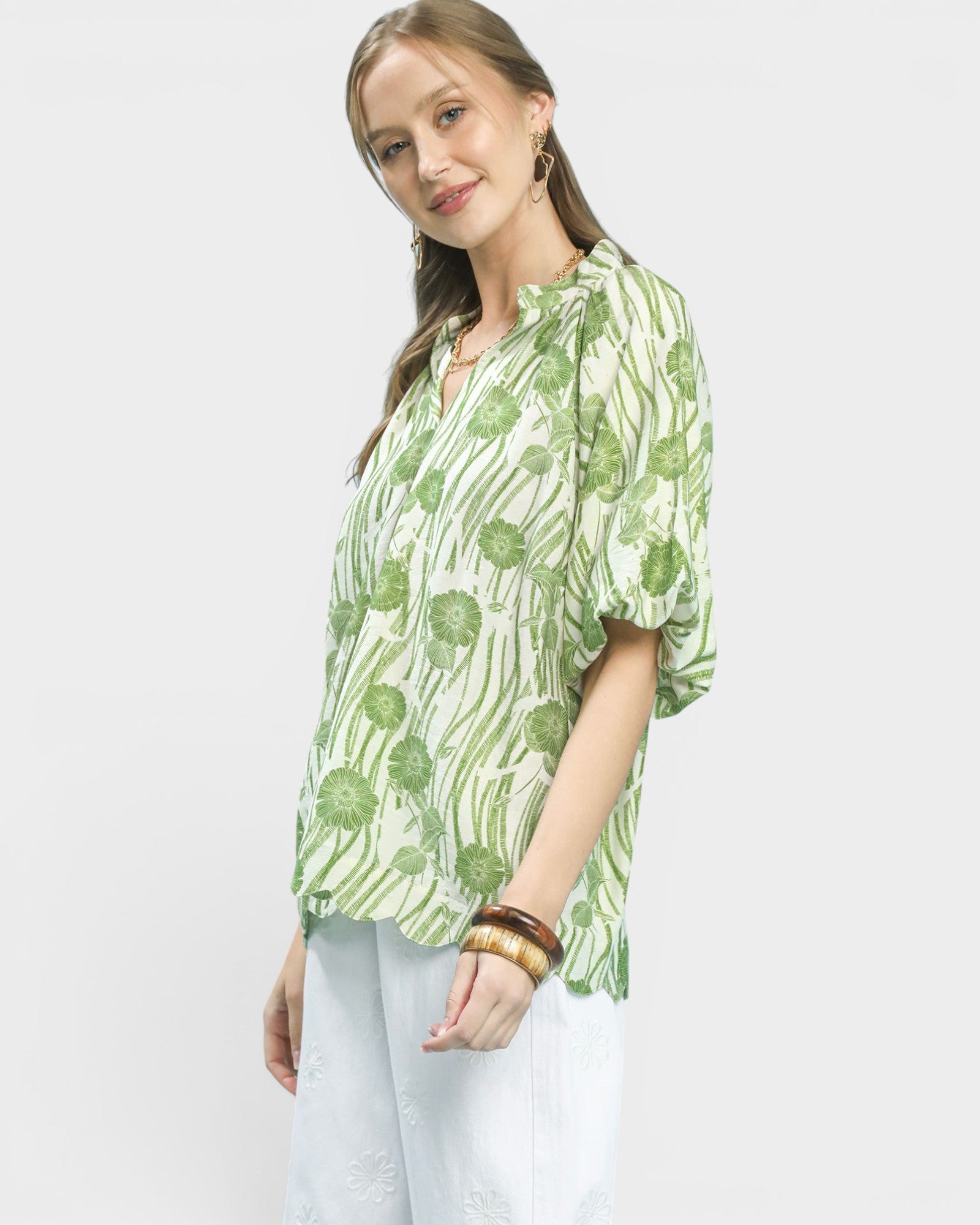 Woman wearing a green floral blouse against a white background